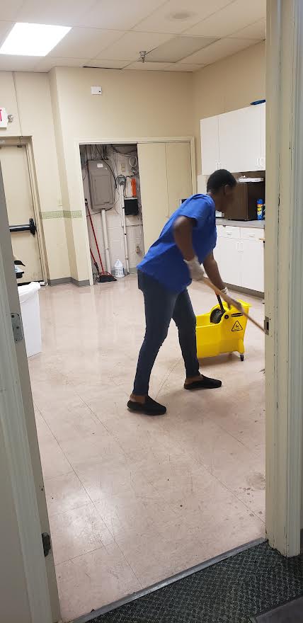 worker mopping down tile floor